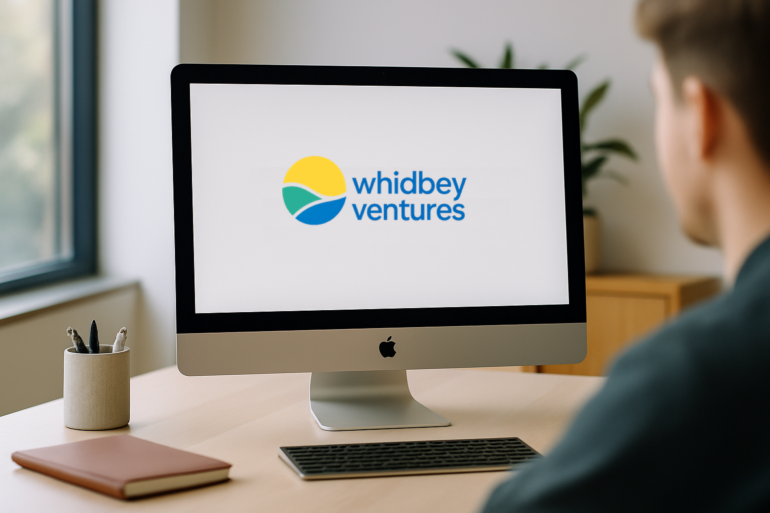 Modern workspace showing Whidbey Ventures website on an iMac, representing our digital-first approach to connecting with partners and clients